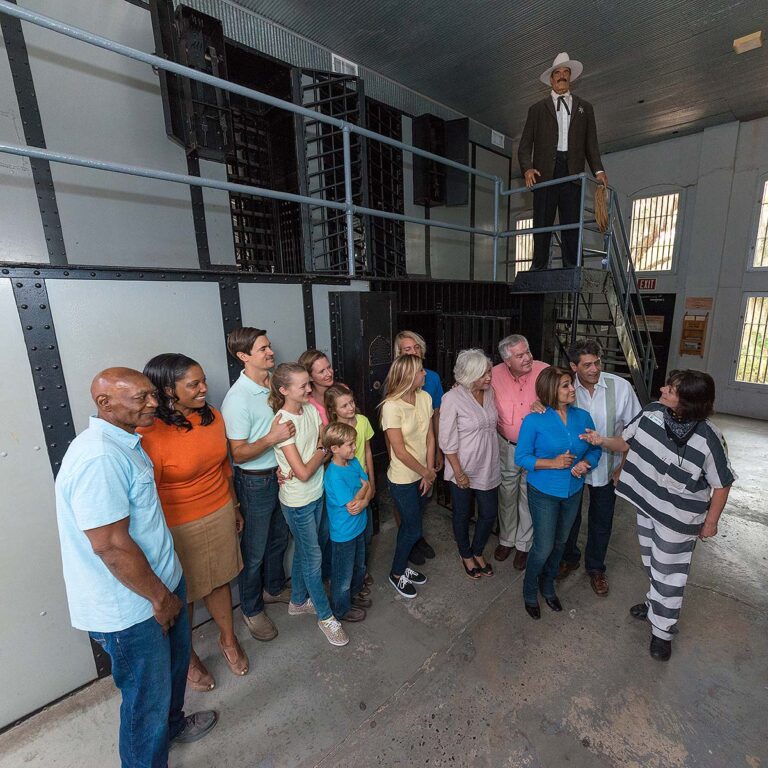 guests and guide inside the Old Jail with sheriff looking on